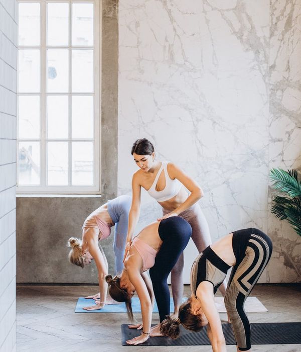 Person stretching gently on a yoga mat in a sunlit room.